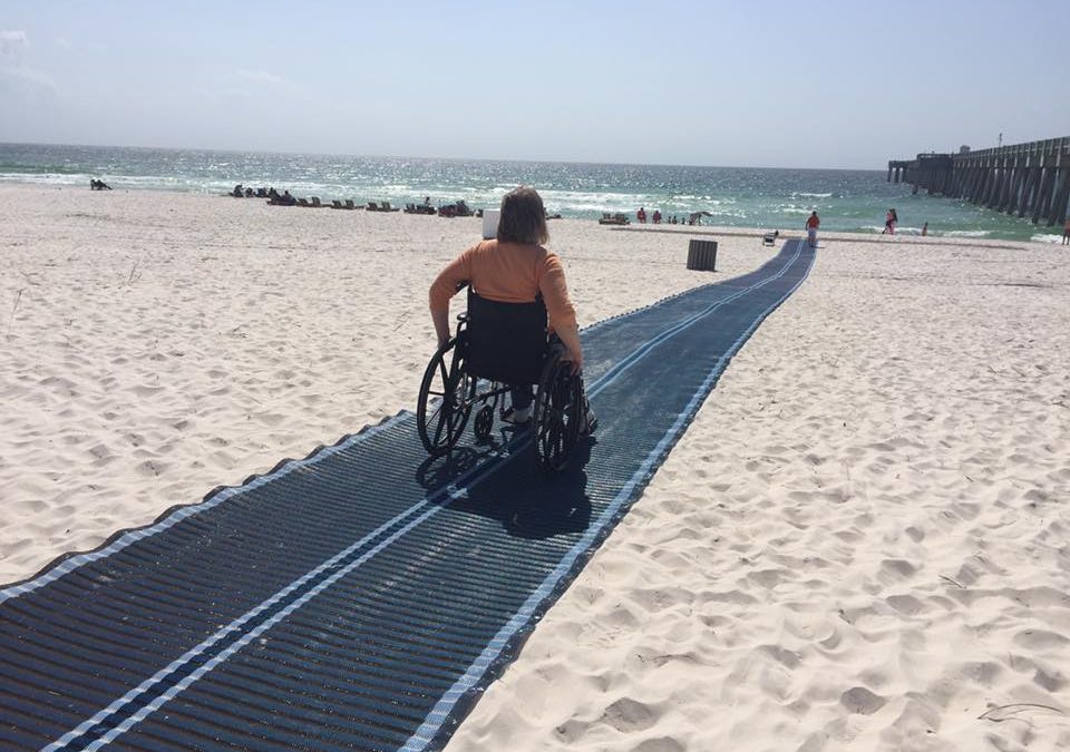 blue accessible matting, female wheelchair user going down to the beach